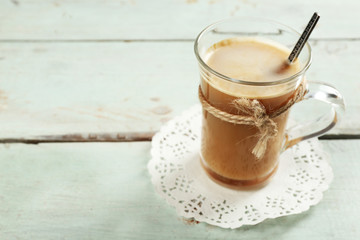 Glass cup of cocoa on color wooden planks background