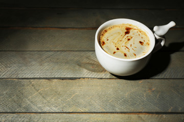 Cup of coffee on rustic wooden planks background