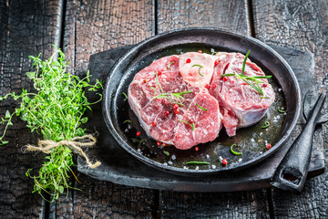 Closeup of red meat with rosemary and pepper ready for grilling