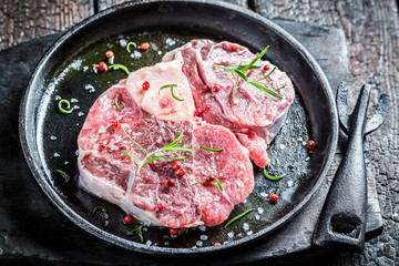 Closeup of red meat with rosemary and pepper ready to grill