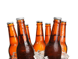 Glass bottles of beer in ice cubes isolated on white - obrazy, fototapety, plakaty