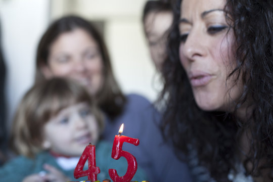 Mujer soplando vela de su 45 cumplea&ntilde;os
