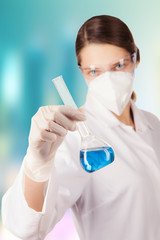 Woman in laboratory holding chemical liquid in glass flask