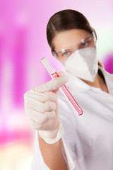 Naklejka premium Woman in laboratory holding chemical liquid in glass vial