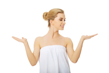 Spa woman wrapped in towel with open hands.