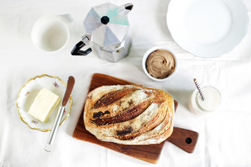 Breakfast of sourdough bread loaf and butter with coffee