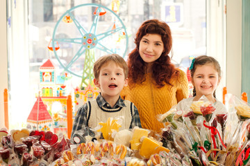 Fototapeta premium Mother with happy children in the candy store