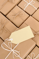 Untidy pile or heap of several lots brown paper wrapped parcel package or gift boxes one unique with label gift tag photo