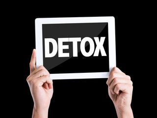 Tablet pc with text Detox isolated on black background