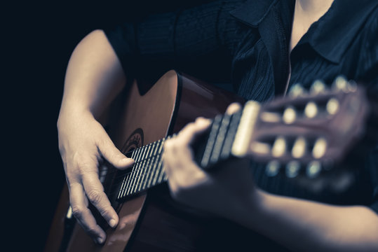 Musician hands playing an acoustic guitar