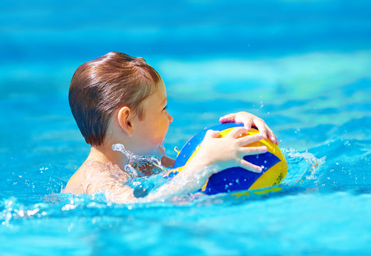 Cute Kid Playing Water Sport Games In Pool