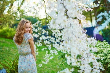 Beautiful girl in cherry blossom garden