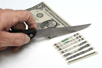US one dollar bill or banknote being cut or sliced into pieces with knife photo