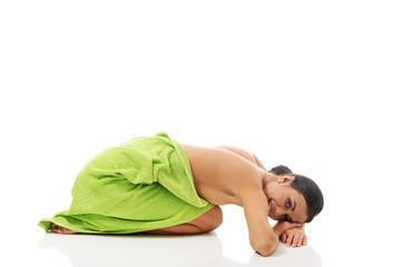 Woman curled up wrapped in towel