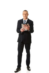 Full length mature man using digital tablet