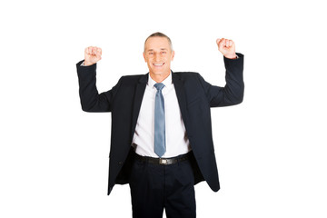 Portrait of successful businessman with arms up