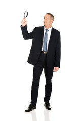 Fototapeta premium Full length businessman with a magnifying glass