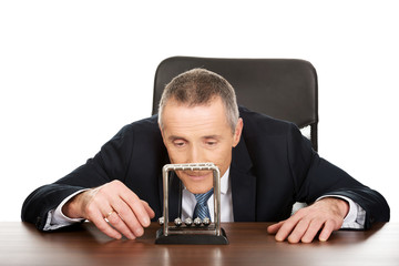 Businessman in office playing with newton balls