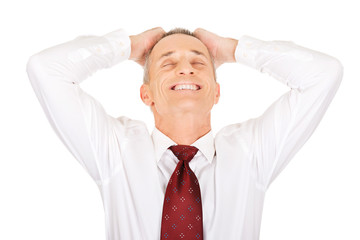 Portrait of businessman holding arms on head