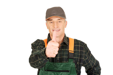 Fototapeta premium Mature gardener in uniform with thumbs up