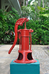 Fototapeta na wymiar Red hand manual water pump in garden