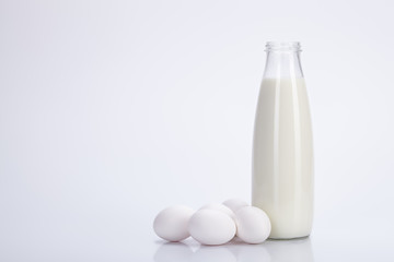 Milk and eggs on white background.