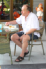 Blurred  men sit eating coffee.