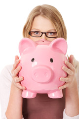 Young woman holding piggybank