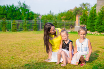 Fototapeta na wymiar Mother and kids sitting outdoors at beautiful summer park