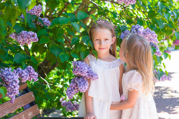 Little adorable girls in lush park in summer vacation