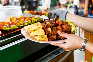 Barbecue grill, placed on a white plate in hand.