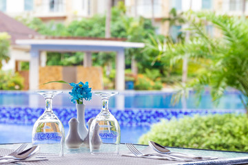 table setup in outdoor cafe, small restaurant at hotel poolside,