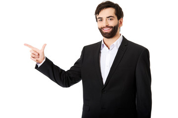 Happy businessman points to the left.