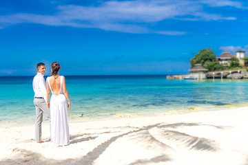 Fototapeta na wymiar young loving couple on their wedding day, outdoor beach wedding