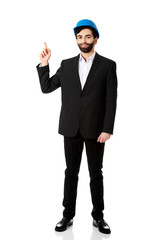 Engineer in protective helmet pointing up.