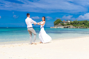 Fototapeta na wymiar young loving couple on their wedding day, outdoor beach wedding