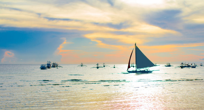 Sailing boat at beautiful colorful sunset