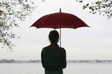 junge Frau mit Regenschirm am Müggelsee, Berlin, Deutschland