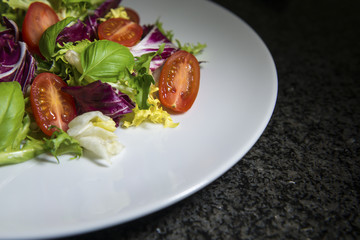 Fresh vibrant salad of lettuce, tomato, and basil
