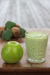 Glass full of apple, broccoli and kiwi milk smoothie.