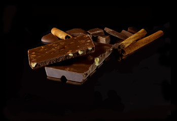 chocolate with nuts and cinnamon on a black background