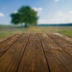 Wooden table outdoors with beautiful field background