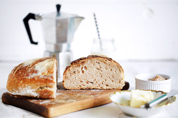 Breakfast table with rustic sourdough bread, butter and coffee