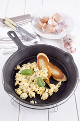 scrambled eggs and toasted bread in a pan