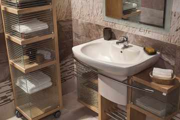 detail of a modern bathroom with sink and cupboard for towels