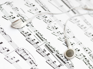 Obraz premium A pair of headphones lying on the sheet with musical notation