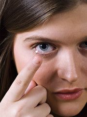 Close-up of blue woman eye with contact lens applying