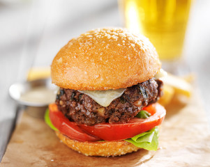 burger with beer and fries served on wax paper