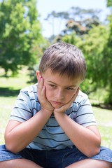 Little boy feeling sad in the park