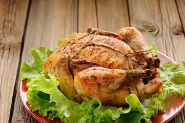 Bondage shibari roasted chicken with salad leaves on red plate o